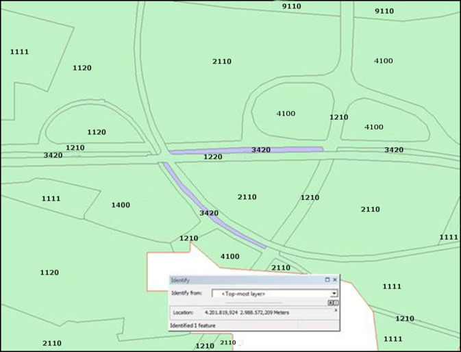 This image displays a land cover/land use map illustrating various classified polygons and linear features, with an overlaid 'Identify' tool window from a Geographic Information System (GIS). The map uses a colour scheme of predominantly light green for classified land cover areas, with light grey lines delineating features like roads and boundaries. Multiple polygons are labelled with four-digit land cover/land use codes: * `1111`: Continuous urban fabric * `1120`: Discontinuous urban fabric * `1210`: Industrial or commercial units * `1220`: Road and rail networks and associated land * `1400`: Sport and leisure facilities * `2110`: Non-irrigated arable land * `3420`: Sclerophyllous vegetation * `4100`: Wetlands * `9110`: An unclarified land cover type within this specific nomenclature. A linear feature, identified as part of the `1220` (Road and rail networks and associated land) and `3420` (Sclerophyllous vegetation) classes, is highlighted in light purple. The 'Identify' tool window shows: * **Identify from:** `<Top-most layer>` * **Location:** `4.201.819,924 2.988.572,209 Meters` * **Identified:** `1 feature` The coordinates are given in meters, indicating a projected Coordinate Reference System (CRS). An area in the bottom right corner is partially outlined in red, possibly indicating an area of interest or a boundary. No scale bar, compass, or specific geographic location is provided on the map itself.